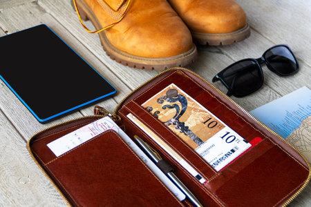 Tracking boot , tickets holder, map and sunglasses on the wooden backgroundの写真素材