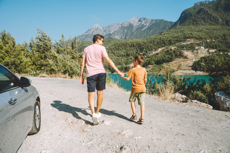 Young dad and his son standing on Mountain View. Child kid boy having fun with father and hiking...