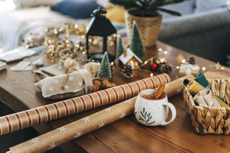Preparing Christmas eco gift. Wrapping paper, wicker basket, coffee cup. Unprepared presents on wooden table with natural decor elements and items Christmas packing wrapping Concept.の写真素材