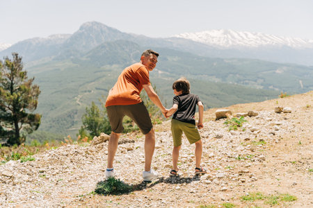 Young dad and his son standing on Mountain View. Child kid boy having fun with father on mountains hiking.の写真素材