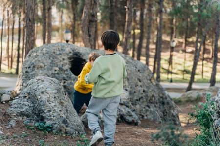 School boys kids playing travel outside in the forest. Siblings brothers children taking a hike in the rocky boulder forest city park.の写真素材