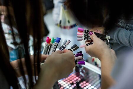the client in the salon of manicure chooses the color of nail Polish.の写真素材