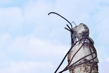 Remains of the destroyed industrial building. A piece of concrete beams with the rebar looks up to...