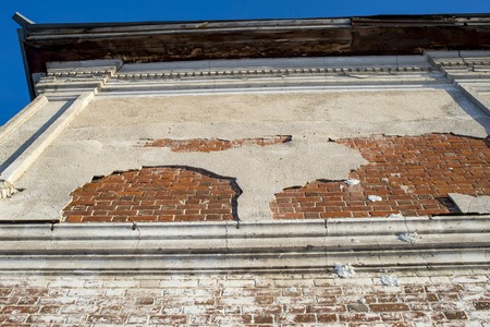 Restoration of the ancient building. Bottom view of part of the wall of the building with stucco on...