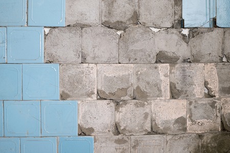 Concrete old wall with the remains of tiles and tile mortar. Background, texture