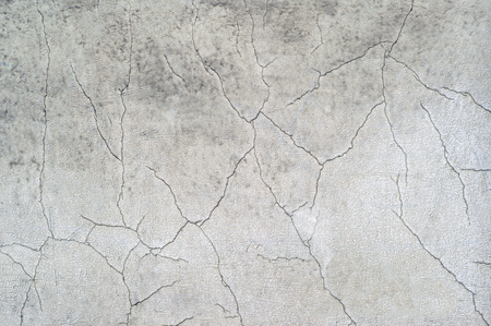 White concrete wall of the old house with curly cracks and swollen white paint. Background.の写真素材