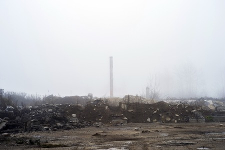 The remains of a large concrete building in the misty haze in the form of fragments of piles and piles of stones.の写真素材