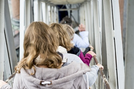 Blur. Women tourists descend the metal stairs from the colonnade of St. Isaac's Cathedral in St....