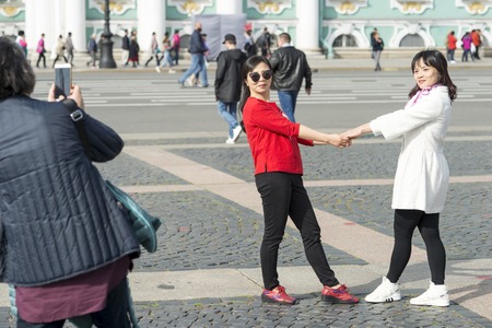 Young women of Asian appearance are photographed on Palace square against the background of the...