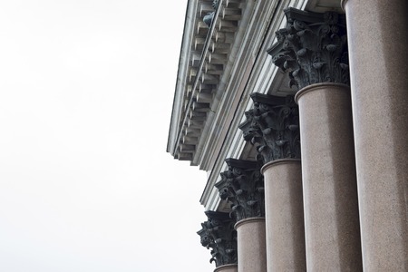 Granite columns of the facade of St. Isaac's Cathedral against the gray sky in St. Petersburg. Background. Copy space. Background. Side view from below. Copy space.の写真素材