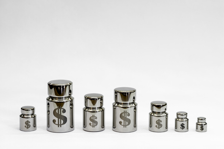 Chart of metal weights with laser engraving symbols of the dollar on a light gray background.の写真素材
