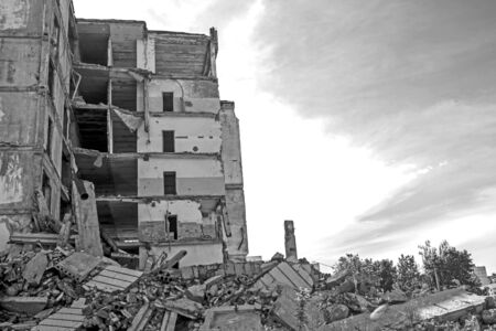 Destroyed large building with a blockage of concrete debris in the foreground. Background. Black and...