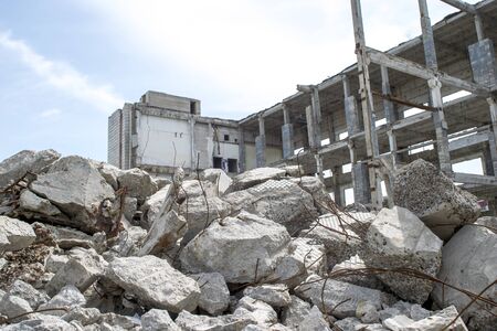 Concrete gray debris close-up on the background of the remains of the destroyed building against the sky. Backgroundの写真素材