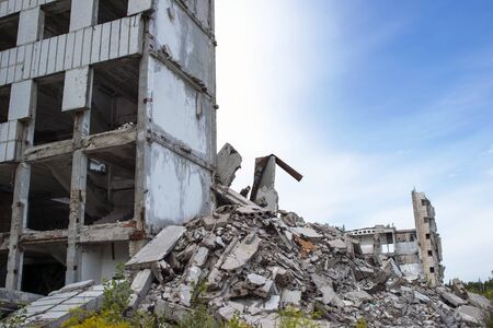 A pile of concrete debris with the remains of a large building against the blue sky. Background. Text spaceの写真素材