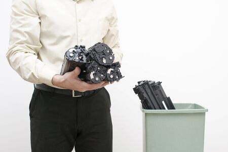 A man is holding cartridges in a close-up group on the background of a container with spent cartridges.の写真素材