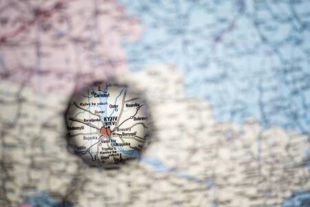 Kiev Ukraine capital close-up through a magnifying glass on the background of a blurred geographical...