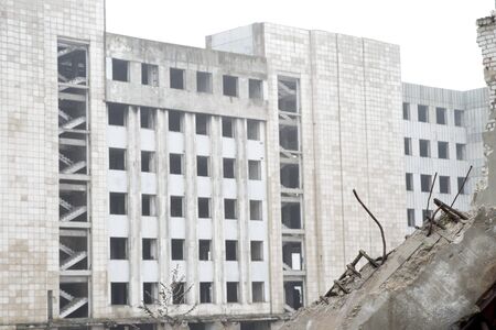 Fragments of concrete stones with protruding reinforcement on the background of the building in a foggy haze. Background.の写真素材