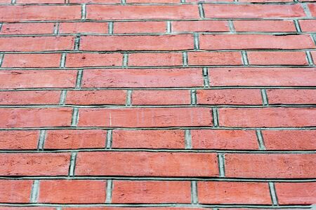 Red brick wall with large grey mortar joints. Bottom view. Background.の写真素材