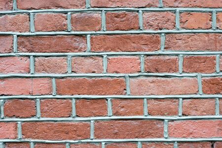 The brick wall is red with a brown tint with voluminous gray joints of the solution. Textured background.の写真素材