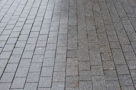 The sidewalk is paved with granite with uneven lighting gradient. Background.の写真素材