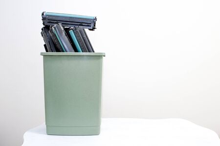Spent cartridges stacked in a container on a white background. The concept of the problem of disposal of harmful chemical waste of office equipment.の写真素材