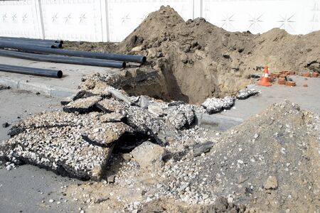 Laying a cold water sewer pipeline in the city asphalt. Background.の写真素材