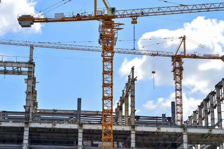 The construction of high-rise buildings, the supply of building materials with the help of a craneの写真素材