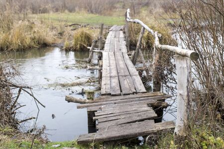 Wooden bridge over a small river in the village in autumn. Background. The way of village life in...