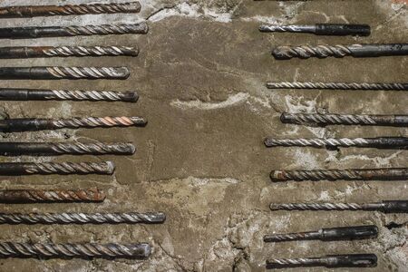Drills on concrete of different diameter and degree of novelty for a perforator lie on a concrete plate in cracks.の写真素材