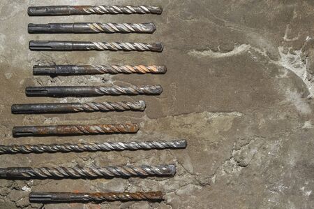 Drills on concrete of different diameter and degree of novelty for a perforator lie on a concrete plate in cracks.の写真素材