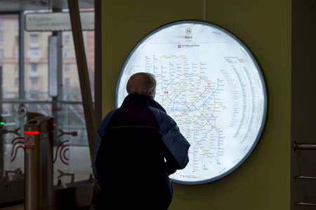 An elderly man studies a metro map at Sorge station, Moscow, Russia, March 2020.