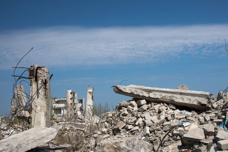 The remains of a destroyed building against a textured blue sky