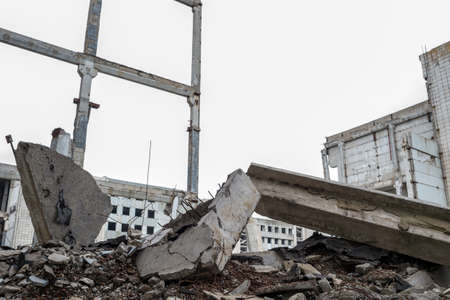 Large gray concrete fragments against the destroyed frame of the building and the overcast sky. Background.の写真素材