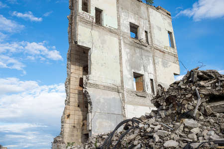 Concrete fragments of construction debris against the remains of the wall of a destroyed building....