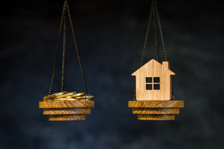 The scales with the coins and the home of the imitation of bamboo. The concept of purchasing housing, credit, and quotes on the real estate market.の写真素材