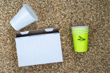 Cardboard white box, plastic Cup and paper cups on the background organic texture of dried petals. Background.の写真素材