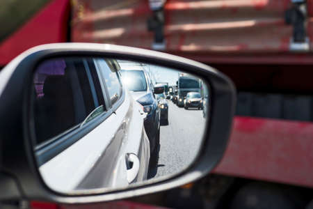 Car rear view mirror with reflection of the traffic flow in the tube. Concept: modern rhythm of life