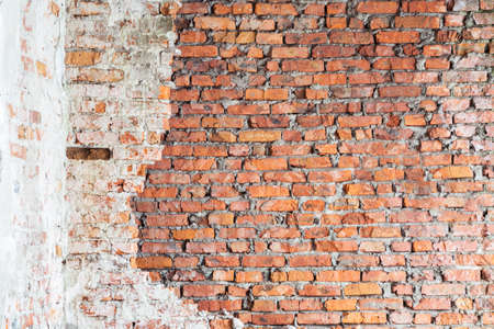 An old red brick wall with remnants of white plaster. vintage background.の写真素材
