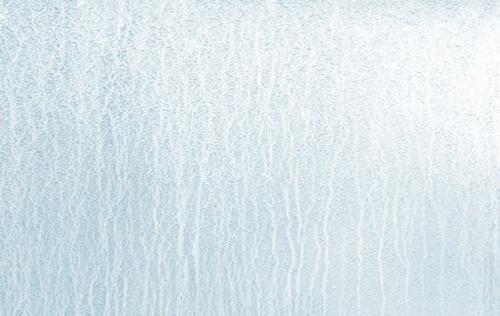 Frozen streams of water with a blue tinge on the glass. The concept of a white textured background.の写真素材