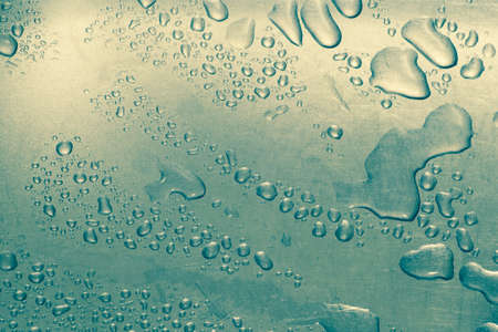 Large and small water drops on a metallic background. tinted image. background.の写真素材