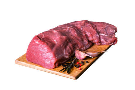 Fresh raw veal tenderloin meat in a large piece on a wooden cutting board is isolated on a white background.の写真素材