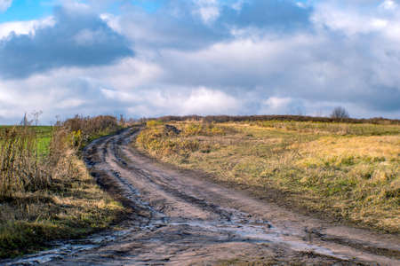 A blurred dirt road through a field going into the distance. background.の写真素材