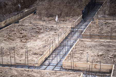 The beginning of the construction of the house with the preparation of pouring the concrete foundation into the welded structure of the reinforcement. background.の写真素材