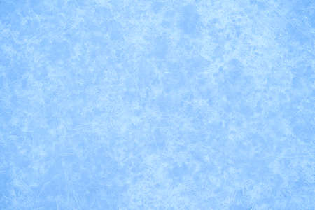 Luminous festive background of blue ice with a white ice pattern with a natural haze effect. background.の写真素材