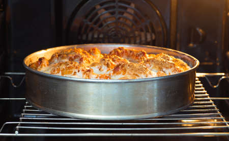 Fish pie with vegetables in a metal form with a Golden crust on the grill in the oven. The concept of baking somethingの写真素材