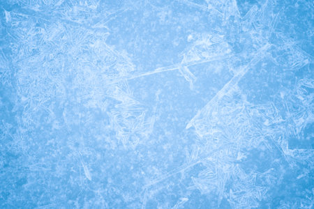 Openwork pattern of blue ice with a layer of white frost, snowflakes and natural illumination. background.の写真素材
