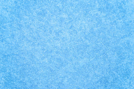 The texture of a frozen window in snowflakes and a blue ice pattern. winter background.の写真素材