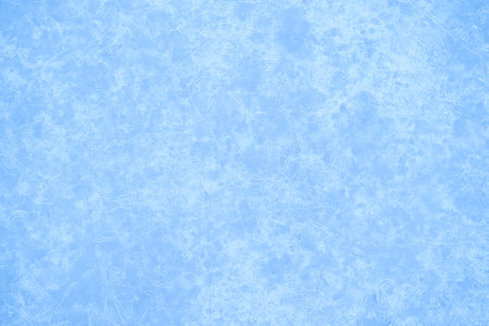 Luminous festive background of blue ice with a white ice pattern with a natural haze effect. background.の写真素材