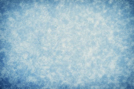 White openwork pattern of ice veins in the haze and frost with illumination on a muted blue background with a grayish tint. background.の写真素材