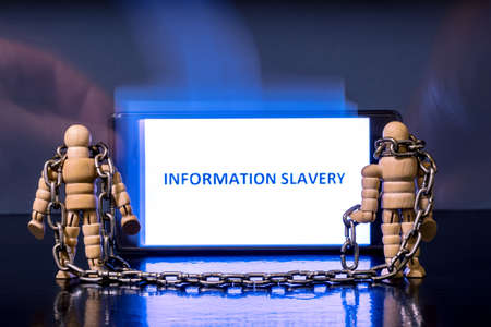 People chained up look at the phone display and blurry translucent hands give the necessary information. Abstract concept of information slavery depending on the source of information. background.の写真素材